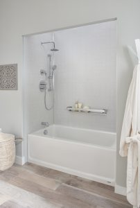 Picture of a beautiful bathroom with gray walls, a gray and white bathtub enclosure, an Ombre teal shower curtain, and a floating gray vanity.