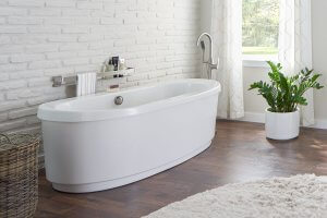 white soaking tub in bathroom with white brick walls